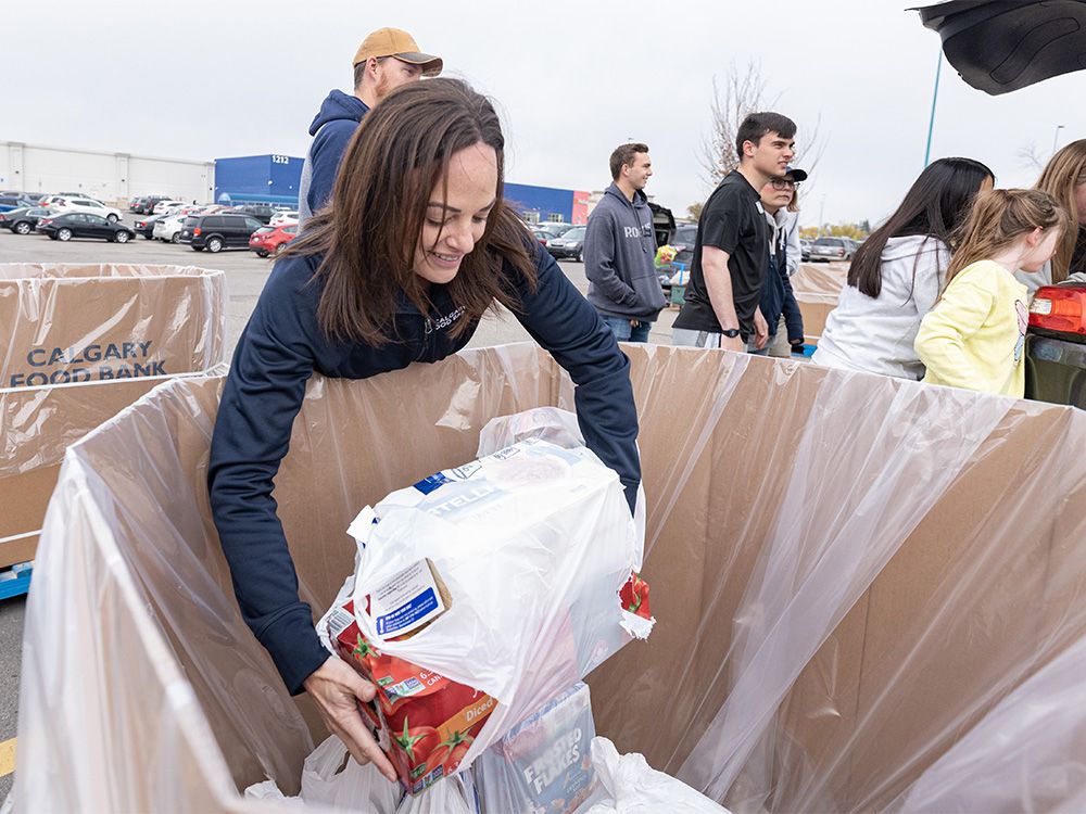Melissa From, CEO and president of the Calgary Food Bank, helps sort the donated items collected in the Citywide Food Drive at the parking lot of Westbrook Mall on Saturday, September 23, 2023.