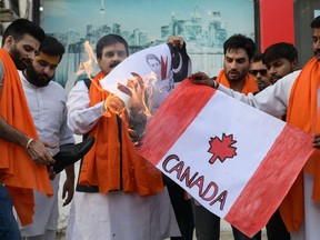 Activists of Shiv Sena Taksali set on fire banners depicting Canada's national flag and Prime Minister Justin Trudeau during a rally along a street in Amritsar on September 23, 2023. (Photo by NARINDER NANU/AFP via Getty Images)