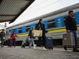 Ukrainians carry their bags as they get off a train from Zaporizhzhia at a train station in Poland.