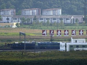 A green train with yellow trimmings, resembling one used by North Korean leader Kim Jong Un on his previous travels, is seen steaming by a slogan which reads "Towards a new victory" on the North Korea border with Russia and China seen from China's Yiyanwang Three Kingdoms viewing platform in Fangchuan in northeastern China's Jilin province on Monday, Sept. 11, 2023.