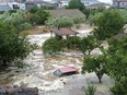 Floodwaters cover a car and the yards of houses in Milina village, Pilion region, central Greece, Tuesday, Sept. 5, 2023. Greek police have ordered vehicles off the streets of the central town of Volos and the nearby mountain region of Pilion as a severe storm has hit the area, turning streets into flooded torrents.