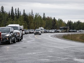 Vehicles line up for fuel at Fort Providence, N.W.T., on the only road south from Yellowknife, Thursday, Aug. 17, 2023. Thousands of vehicles are expected to travel to Yellowknife in the coming days as a three-week evacuation order is set to lift at noon.