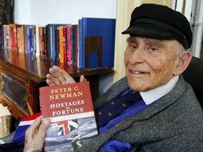 Author Peter C. Newman holds his book, Hostages to Fortune, in his home office in Belleville, Ont. Monday, October 31, 2016.