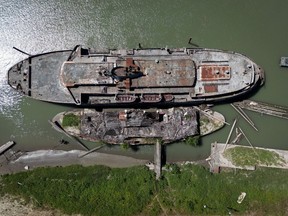 The retired BC Ferries vessel Queen of Sidney, top, that was in operation from 1960 to 2000, and another derelict vessel are seen moored on the Fraser River, in Mission, B.C., on Tuesday, July 18, 2023.