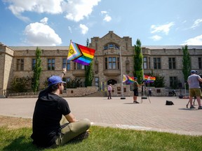A person holds a pride flag during a Pride flag raising ceremony in Saskatoon on Thursday, June 1, 2023. A Saskatchewan judge is to hear today an injunction application that seeks to halt the province's pronoun policy affecting children at school.