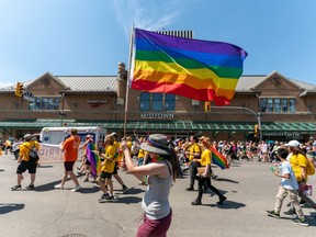 A participant waves a rainbow flag as the crowd marches during Pride Parade in Saskatoon, Sask., on Saturday, June 18, 2022.
