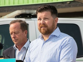 HSAA president Mike Parker (left), and the Towing and Recovery Association of Alberta president Don Getschel, call on Transportation Minister Devin Dreeshen to deliver the protection originally promised to all roadside workers at an NDP news conference on Sept. 1, 2023.
