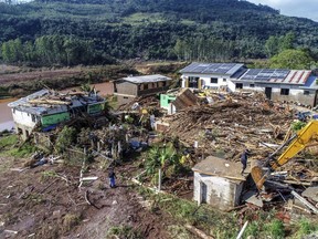 Residents walks amid destroyed houses after floods caused by a deadly cyclone in Mucum, Rio Grande do Sul state, Brazil, Wednesday, Sept. 6, 2023. An extratropical cyclone in southern Brazil caused floods in several cities.