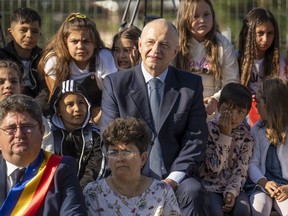 NATO Deputy Secretary General Mircea Geoana sits with children during a school opening ceremony in Ghergani, Romania, Monday, Sept. 11, 2023. According to Eurostat, in 2022 Romania had the highest percentage of early school leavers in the European union with 16 percent of youngsters between the ages of 18 and 24 abandoning education.