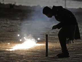 An Edmonton man lights fireworks during a celebration of Diwali at the Bhartiya Cultural Centre in Edmonton. Last year Environment Canada issued an air quality warning tied to the festival.