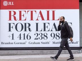 A pedestrian walks past commercial real estate for lease in Toronto.