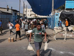 Palestinians storm a UN-run aid supply center, that distributes food to displaced families following Israel's call for more than one million residents in northern Gaza to move south for their safety, in Deir al-Balah on Oct. 28, 2023, amid the ongoing battles between Israel and the Palestinian group Hamas.