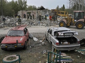 Ukrainian emergency personnel clear debris on the site of a Russian strike which hit a shop and cafe in the village of Groza, on October 6, 2023.