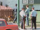 Calgary police investigate the scene where Barry Buchart and his roommate, Trevor Deakins were fatally shot at a fourplex in Calgary on July 11, 1994.