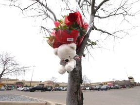 Flowers and a teddy bear are shown strapped to a tree on Wednesday, November 15, 2023 at the scene of a fatal shooting at the TransCanada Centre in northeast Calgary