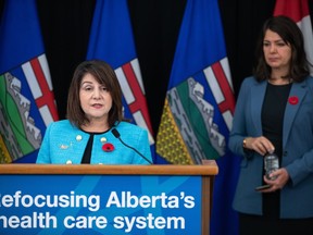 Adriana LaGrange, minister of health, speaks about health-care reforms as Alberta Premier Danielle Smith looks on during a news conference in Edmonton on Wednesday Nov. 8, 2023. The board of Alberta Health Services says six of the organization's top executives are no longer in their positions.