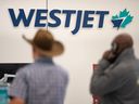 Passengers wait in line at the WestJet counter at Calgary International Airport on Friday, May 19, 2023.