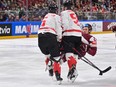 Canada's Jake Middleton and MacKenzie Weegar collide with Latvia forward Rudolfs Balcers.