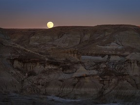 The moon rises over the badlands near Steveville, Ab., on Tuesday, December 26, 2023.