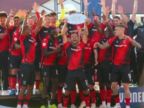Sergio Camargo hoists the Canadian Premier League Shield as Cavalry FC celebrates their regular-season titl on ATCO Field at Spruce Meadows on Oct. 7, 2023.