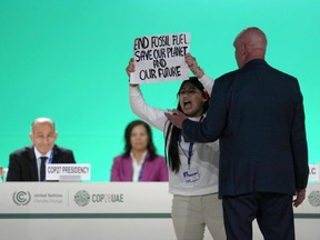 A woman protests against the use of fossil fuels during an event at the COP28 UN Climate Summit in Dubai, United Arab Emirates, Monday, Dec. 11, 2023.