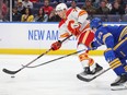 Calgary Flames forward Walker Duehr is schecked by Buffalo Sabres defenceman Mattias Samuelsson at KeyBank Center in Buffalo on Oct. 19, 2023.