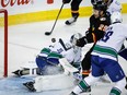 Calgary Flames forward Dillon Dube tries to swat the puck into the net as Vancouver Canucks goalie Thatcher Demko looks on at the Scotiabank Saddledome in Calgary on Saturday, Dec. 2, 2023. Dube did not score on the play.