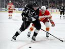 Center Los Angeles Kings Anze Kopitar (vľavo) kontroluje puk vedľa centra Calgary Flames Blakea Colemana počas druhej tretiny hokejového zápasu NHL v Los Angeles, v sobotu 23. decembra 2023.
