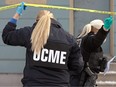 A Winnipeg Police forensics officer and an Office of the Chief Medical Examiner investigator enter the multiple homicide scene at Langside Street in Winnipeg on Monday, Nov. 27, 2023.