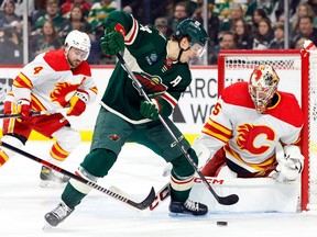 Jacob Markstrom #25 of the Calgary Flames defends the net against Joel Eriksson Ek #14 of the Minnesota Wild in the first period at Xcel Energy Center
