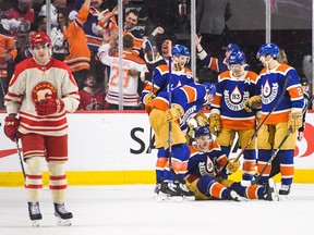 Zach Hyman #18 of the Edmonton Oilers gets congratulated by his teammates after scoring against the Calgary Flames during the third period of an NHL game at Scotiabank Saddledome