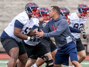 Montreal Alouettes assistant coach André Bolduc takes on offensive lineman Jarvis Harrison during first day of rookie camp in Montreal Wednesday May 15, 2019. The Calgary Stampeders have hired Bolduc as their running backs coach.