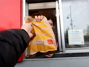 A single-use bag is handed to a customer at a fast food drive-thru