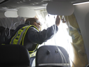 National Transportation Safety Board Investigator-in-Charge John Lovell examines the fuselage plug area of Alaska Airlines Flight 1282 Jan. 7, 2024, in Portland, Ore. A panel used to plug an area reserved for an exit door on the Boeing 737 Max 9 jetliner blew out Friday night shortly after the flight took off from Portland, forcing the plane to return to Portland International Airport.