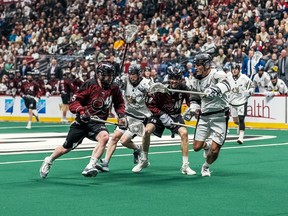 Dylan Kinnear of Colorado attempts to get around a couple Calgary players Calgary Roughnecks at Colorado Mammoth on 01/20/24 from Ball Arena in Denver Colorado