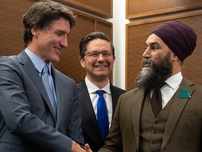 Prime Minister Justin Trudeau shakes hands with New Democratic Party leader Jagmeet Singh as Conservative leader Pierre Poilievre looks on at a Tamil heritage month reception, Monday, January 30, 2023 in Ottawa.