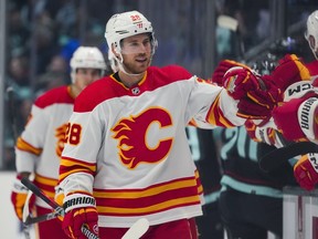 Calgary Flames center Elias Lindholm greets the bench after scoring against the Seattle Kraken during the first period of an NHL hockey game