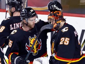 Calgary Flames goalie Jacob Markstrom, celebrates with Noah Hanifin after defeating the Chicago Blackhawks in NHL hockey action in Calgary