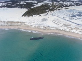 The massive, overturned hull of a seemingly ancient ship has appeared without warning along Newfoundland's southwestern tip as shown in this handout image provided by Corey Purchase. Wanda Blackmore says her 21-year-old son, Gordon, came roaring into her house last Saturday morning after spotting the long shadow beneath the water just off the beach in Cape Ray, N.L.
