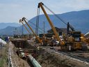 Workers lay pipe during construction of the Trans Mountain pipeline expansion, in Abbotsford, B.C., on Wednesday, May 3, 2023. The Canada Energy Regulator is slated to hear oral arguments Friday from the company building the Trans Mountain pipeline expansion on its request for a pipeline variance.THE CANADIAN PRESS/Darryl Dyck