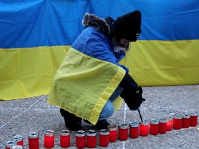 Edmontonians light candles as they mark the one-year anniversary of Russia's full-scale invasion of Ukraine with a vigil outside the Alberta Legislature in Edmonton, Friday Feb. 24, 2023.