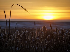 The sun drops behind clouds over Parflesh Creek west of Standard, Ab., on Tuesday, February 27, 2024.