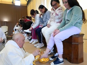 This photo taken and handout on March 28, 2024 by The Vatican Media shows Pope Francis performing the "Washing of the Feet" of inmates during a private visit at the Rebibbia prison for women in Rome as part of Holy Thursday, during Easter celebrations.