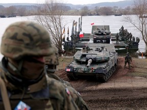 A Polish soldier stands by as a Polish Leopard 2PL tank descends from a M3 amphibious rig during a NATO Dragon 24 military exercise on March 04, 2024 near Gniew, Poland.