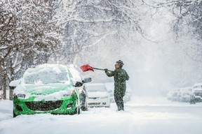 Rita Gerritsen clears off her car in Tuxedo as heavy snow fell in Calgary on Saturday, March 2, 2024. 
Gavin Young/Postmedia