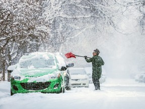 Rita Gerritsen clears off her car in Tuxedo as heavy snow fell in Calgary on Saturday, March 2, 2024. 
Gavin Young/Postmedia