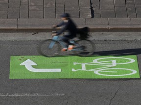 A cyclist makes their way along a roadway in a lane marked for bicycles, Wednesday, Nov. 2, 2022 in Ottawa. Bodies and minds are just as affected by climate change as sea ice and forests, says University of Alberta scientist Sherilee Harper.