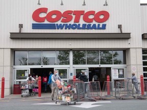 Shoppers walk out with full carts from a Costco store in Washington, DC, on May 5, 2020.