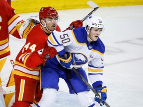 Buffalo Sabres forward Eric Robinson (50) is checked by Calgary Flames defenceman Joel Hanley (44) during second period NHL hockey action in Calgary