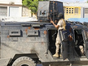 Police take cover during an anti-gang operation in Port-au-Prince, Haiti, Friday, March 1, 2024.